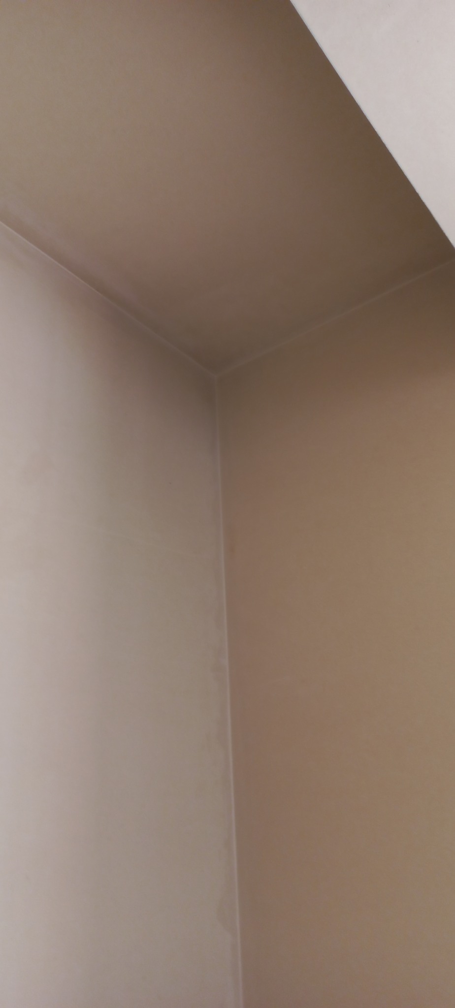 Wnętrze po nałożeniu gładzi, widoczny narożnik ścian i fragment sufitu, gotowe do malowania.