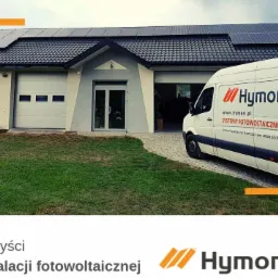 Biały van firmy z logo na tle domu z panelami słonecznymi na dachu i otwartym garażem.