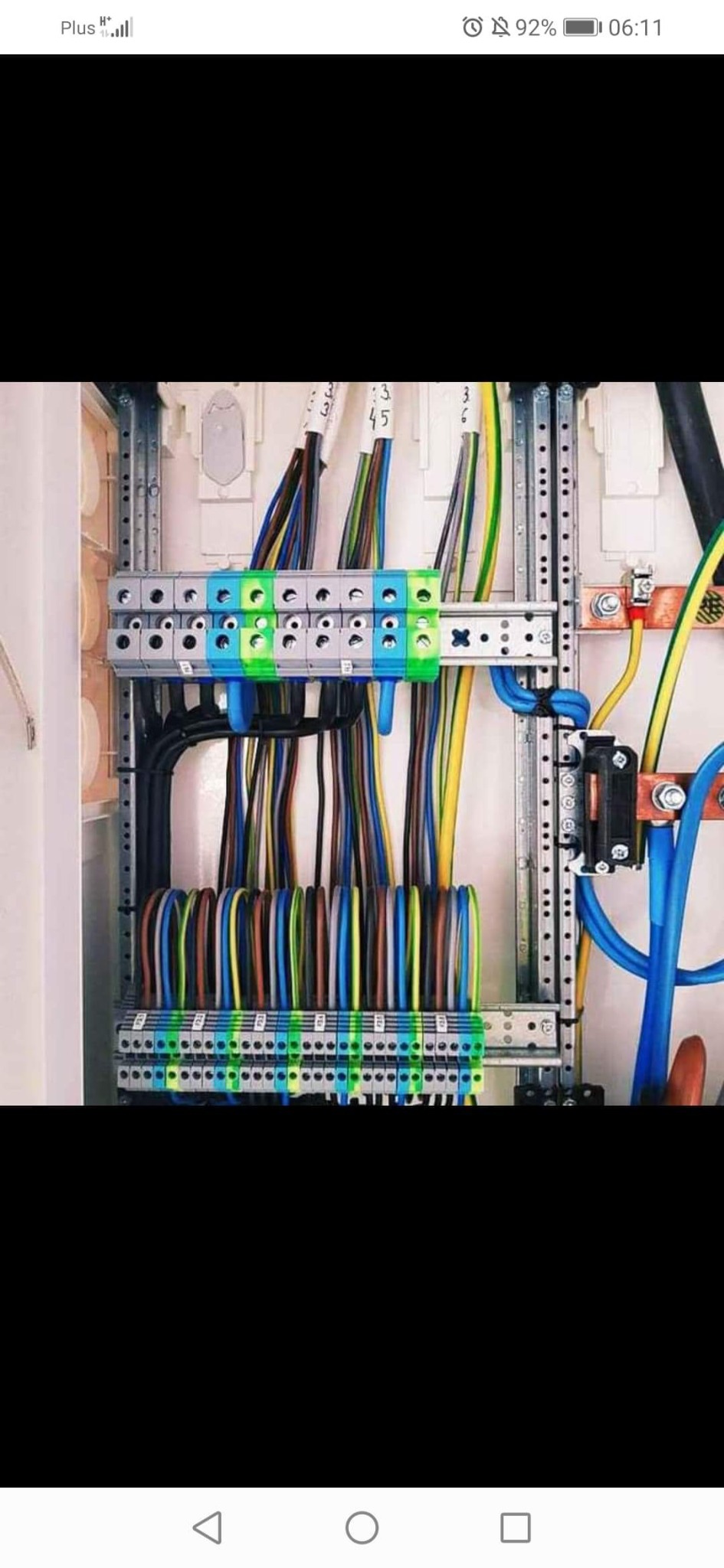 Rozdzielnica elektryczna z uporządkowanymi przewodami o różnych kolorach, zamocowanymi do listew zaciskowych; widoczne oznaczenia numerów na przewodach.