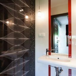 M-Bud - Nowoczesna łazienka z czarno-białymi płytkami z motywem fal, umywalką na postumencie i lustrem w czerwonej ramie.