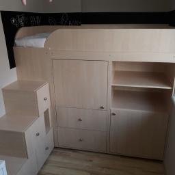 Mebleak-Meble na wymiar - Białe łóżko piętrowe zintegrowane z szafkami i schodkami, rysunki kredą na czarnej ścianie w tle.