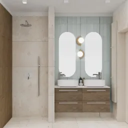 Nowoczesna łazienka z kabiną prysznicową typu walk-in, podwójną umywalką nablatową na drewnianej szafce z szufladami i dwoma owalnymi lustrami podświetlonymi dekoracyjnymi lampami ściennymi.