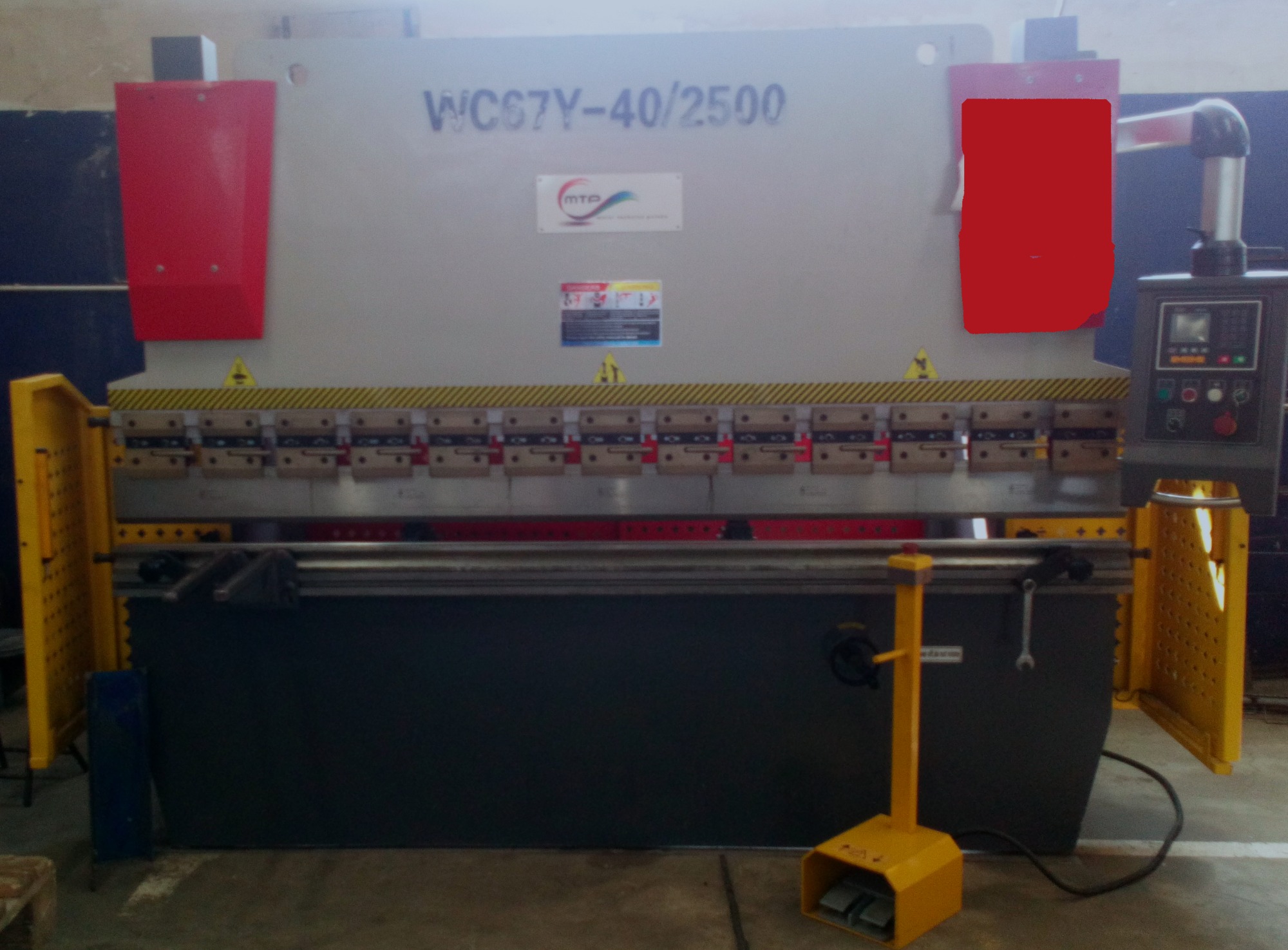 Przemysłowa prasa krawędziowa z żółtą osłoną i pedałem nożnym, widoczne oznaczenia modelu WC67Y-40/2500 oraz panel sterowania.