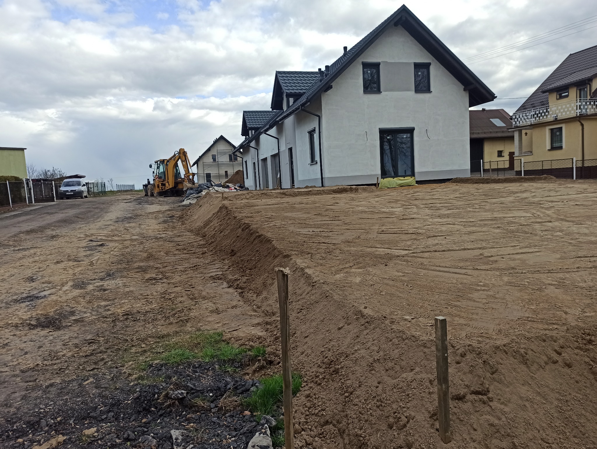 Nasypanie rozplantowanie ziemi na działce koło domu. Zrobienie skarpy.