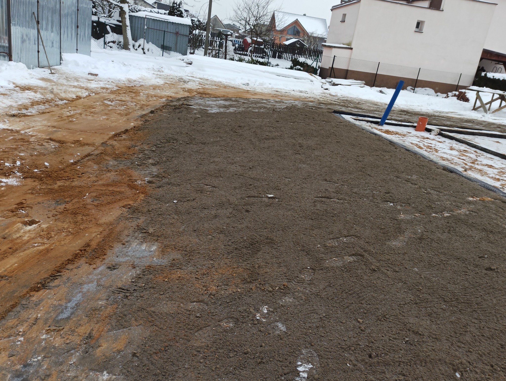 Zasypanie fundamentów piaskiem. Rozplantowanie ziemi wokół fundamentów.