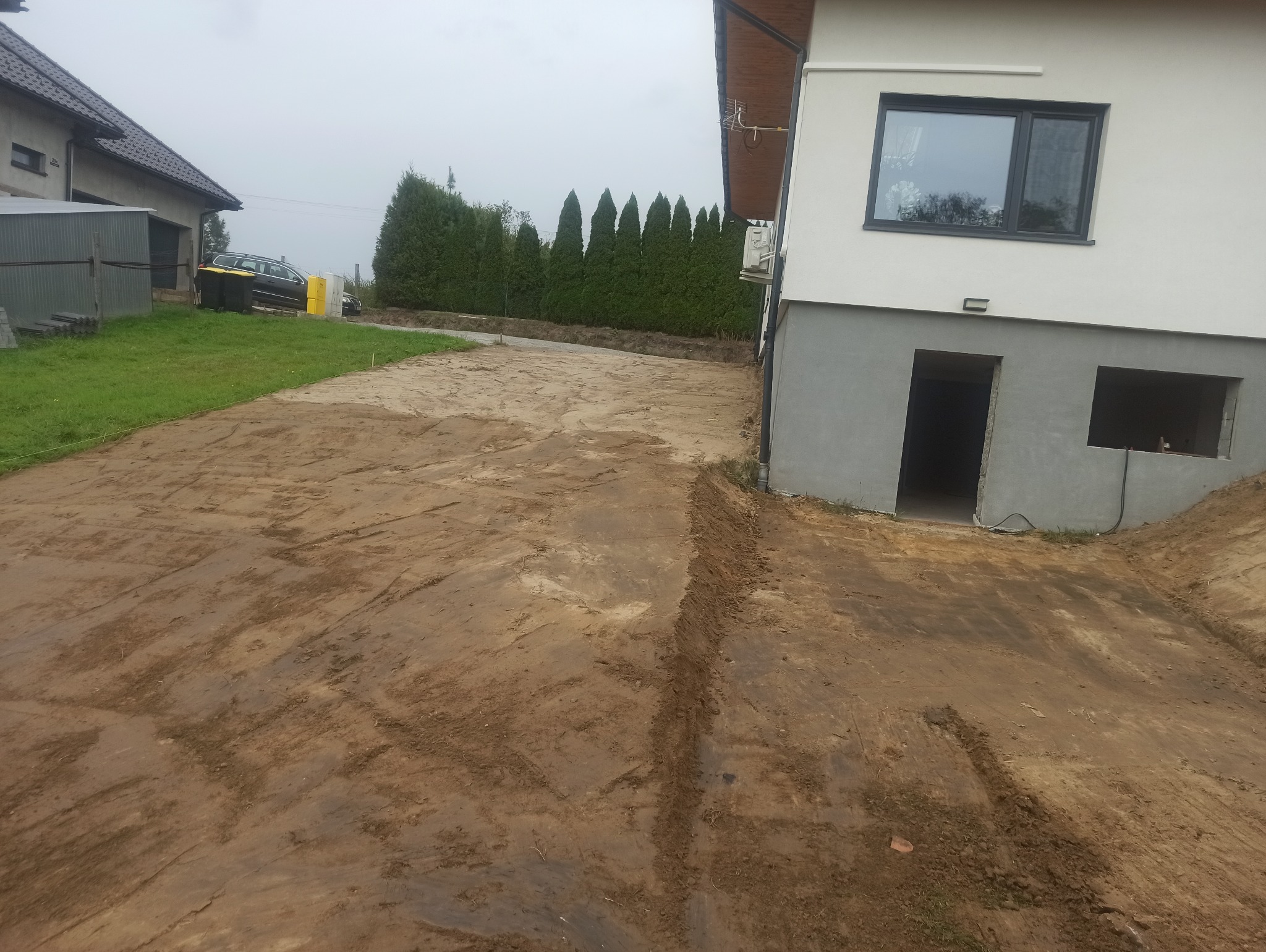 Plantowanie ziemi wokół domu. Zrobienie skarp.