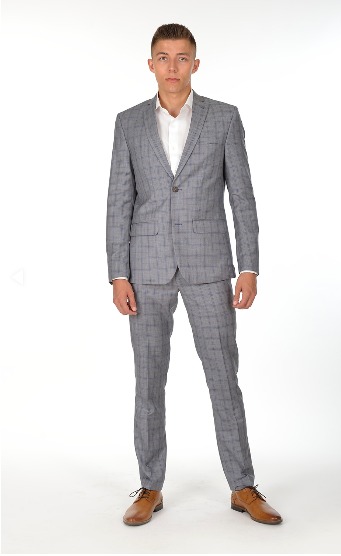 Młody mężczyzna prezentuje szary garnitur w kratę z Częstochowy, biała koszula i brązowe buty na jednolitym białym tle.