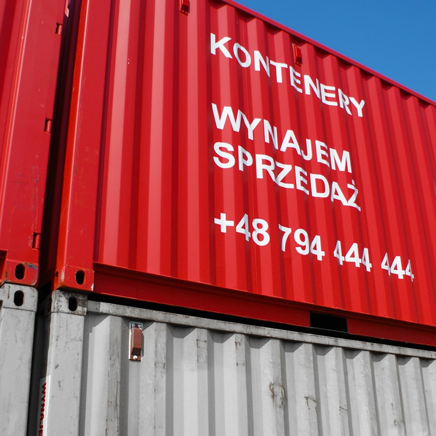 Dwa ustawione jeden na drugim kontenery: górny czerwony z białym napisem 'KONTENERY WYNAJEM SPRZEDAŻ +48 794 444 444', dolny szary.