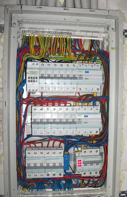 Rozdzielnica elektryczna z zainstalowanymi bezpiecznikami i okablowaniem w Obrowie, widok z bliska na elementy zabezpieczające instalację.