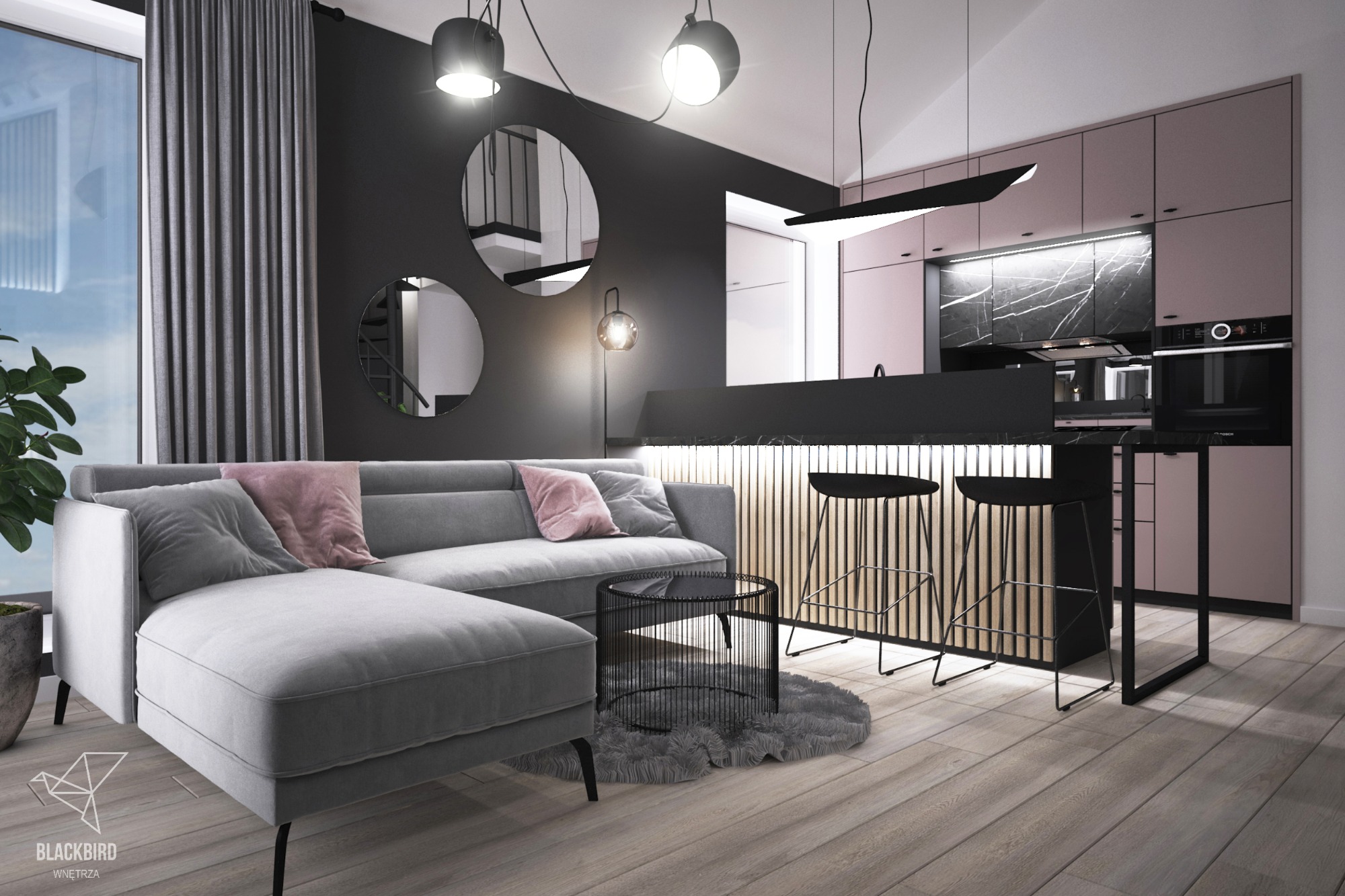 Nowoczesne wnętrze z szarą sofą narożną, okrągłymi lustrami na czarnej ścianie, drewnianą podłogą i różową zabudową kuchenną z czarnym marmurem, oświetlone wiszącymi lampami.
