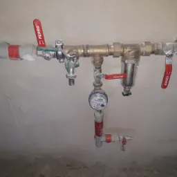 Kompletna instalacja wodna z filtrem, licznikiem i zaworami Ferro, zamontowana na surowej ścianie.
