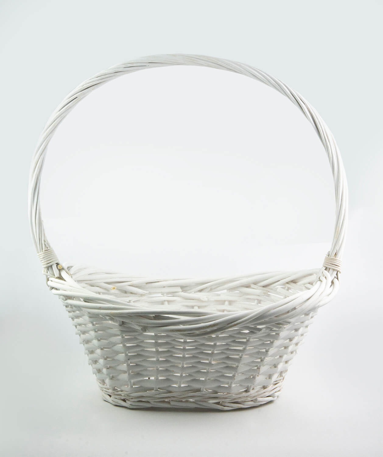 Pusta, biała, wiklinowa koszyczka z uchwytem, ustawiona na białym tle.