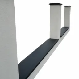 Fragment ogrodzenia betonowego z płaskimi, fazowanymi nakrywkami w kolorze antracytowym, widok z dołu, białe słupki o fakturze baranka.