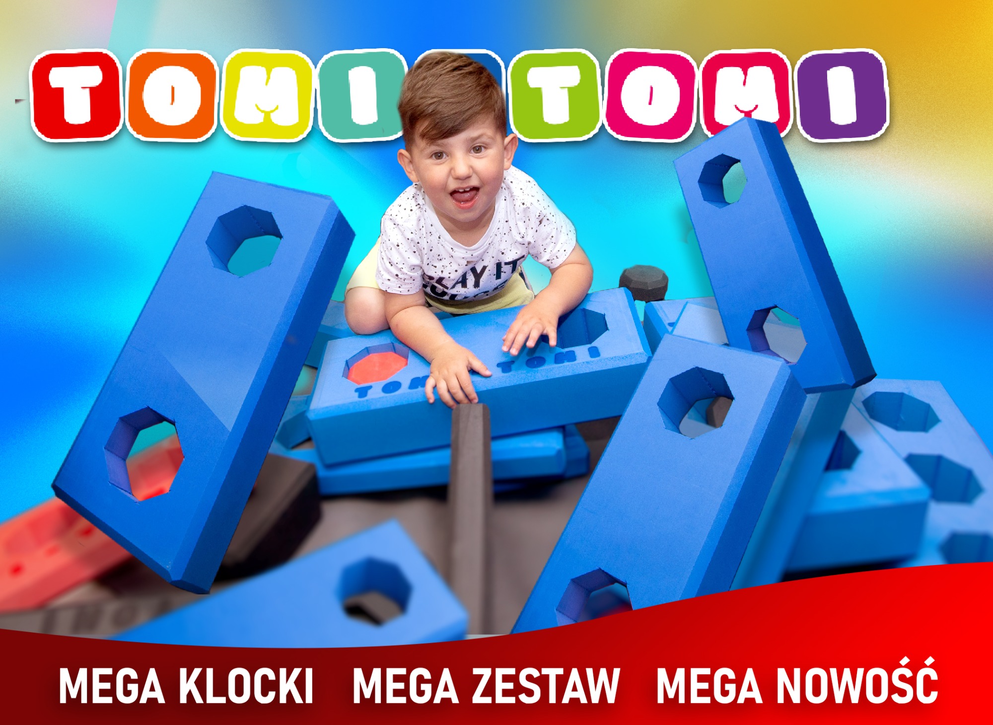 Uśmiechnięty chłopiec bawi się dużymi, niebieskimi klockami piankowymi z otworami, tworząc konstrukcję w radosnej atmosferze.