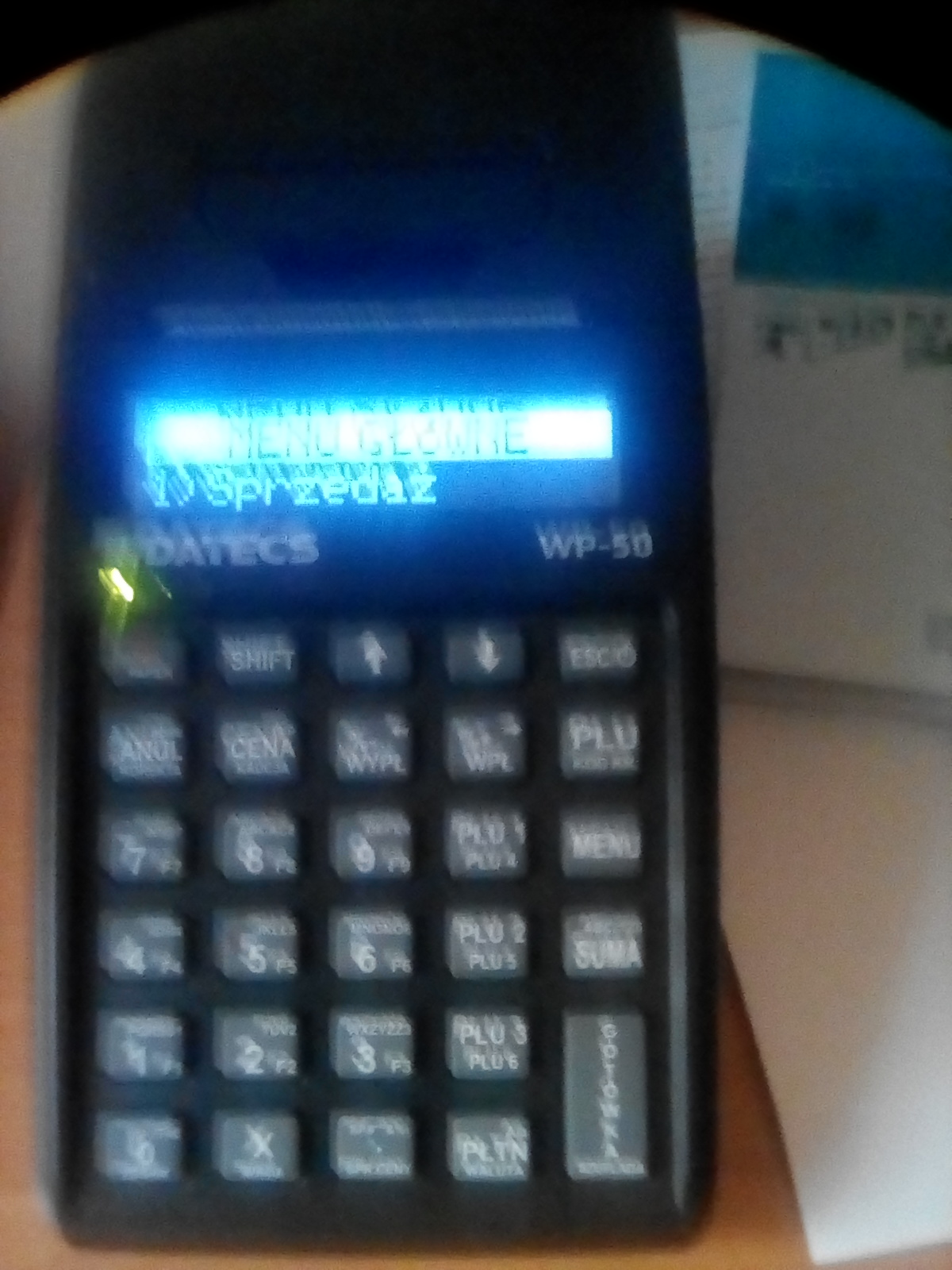 Czarny terminal płatniczy Datecs WP-50 z podświetlonym ekranem LCD wyświetlającym tekst 'MENU GŁÓWNE' i 'Sprzedaż', widoczne przyciski funkcyjne i numeryczne.