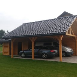 Usługi Ciesielsko-Dekarskie - Drewniana konstrukcja z dwuspadowym dachem z dachówki ceramicznej, służąca jako zadaszenie dla dwóch samochodów, z dodatkowym pomieszczeniem gospodarczym z boku.