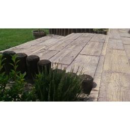 PPHU KAMWER Paulina Wera - Nawierzchnia tarasu z betonowych płyt imitujących drewno, obrzeże z drewnianych bali, widok z poziomu gruntu.