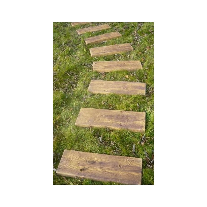 Ścieżka z drewnopodobnych płyt ułożona w trawie, prowadząca przez ogród, widoczne sęki i usłojenie drewna.