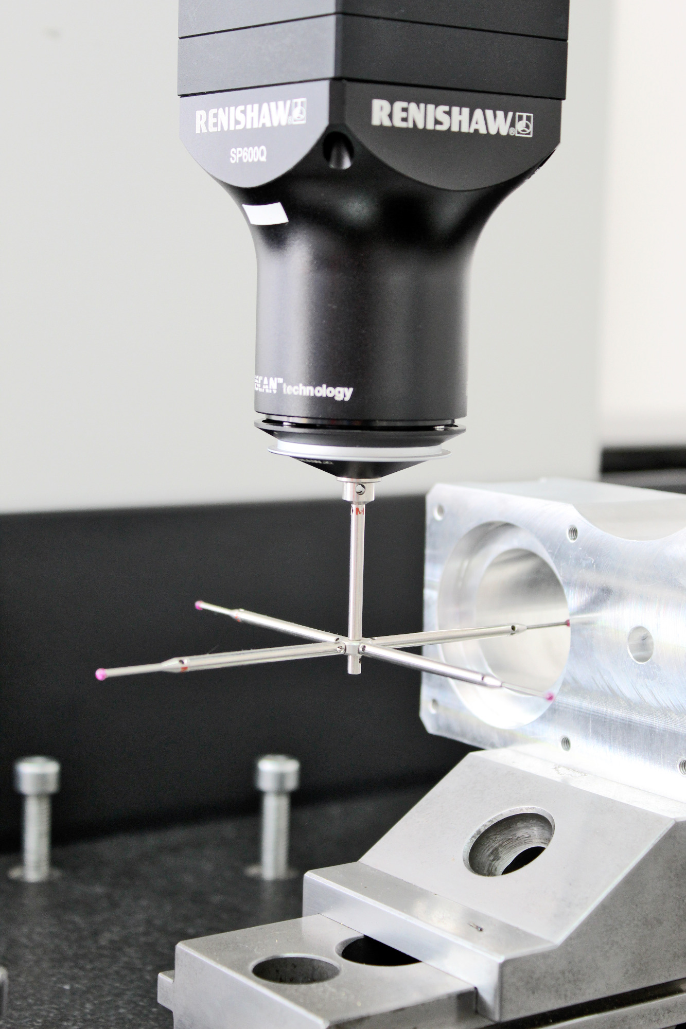 Precyzyjny pomiar detalu maszynowego za pomocą 3-osiowej maszyny pomiarowej Renishaw SP600Q z głowicą dotykową i trzpieniami pomiarowymi z rubinowymi końcówkami, ustawionej na granitowej płycie...