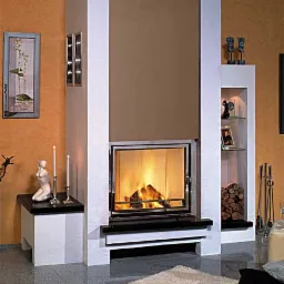 Nowoczesny kominek z obudową w odcieniach bieli i brązu, z paleniskiem za szybą i dekoracyjnymi elementami, takimi jak figurka i świece na bocznej półce.