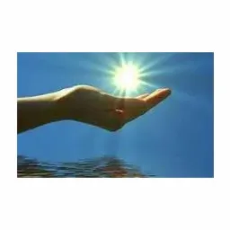 Dłoń wyciągnięta w kierunku słońca na tle błękitnego nieba i powierzchni wody.