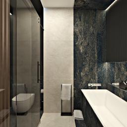 Żeromska Projektowanie wnętrz - Nowoczesna łazienka z kabiną prysznicową ze szklanymi drzwiami, wolnostojącą wanną obudowaną ciemnym kamieniem, jasnymi płytkami na ścianach oraz czarnym grzejnikiem na ręczniki.
