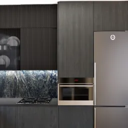 Nowoczesna kuchnia z ciemnymi, drewnianymi szafkami, marmurowym backsplashiem i sprzętem AGD w kolorze srebrnym. W tle widoczny pokój z drewnianą podłogą i regałem.