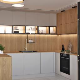 Żeromska Projektowanie wnętrz - Nowoczesna kuchnia z drewnianymi i białymi szafkami, czarnym zlewem i sprzętem SMEG, oświetlona listwami LED pod szafkami wiszącymi z ekspozycją naczyń.