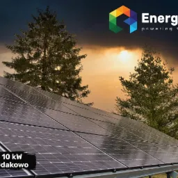 Instalacja paneli słonecznych o mocy 10kW w Gdakowie, na tle zachodzącego słońca i ciemnych chmur, z widocznym logo firmy EnergySet.