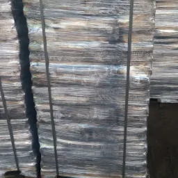 Palety z zapakowanym towarem, zabezpieczone folią i taśmą, ustawione na zewnątrz.