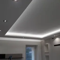 Nowoczesny, wielopoziomowy sufit podwieszany z oświetleniem LED, punktowe lampy wpuszczane, ściany w odcieniach szarości, minimalistyczny design wnętrza.