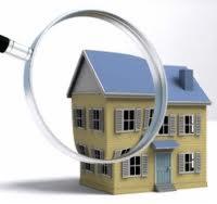 Model domu jednorodzinnego z żółtą elewacją i niebieskim dachem oglądany przez lupę, sugerujący audyt energetyczny.