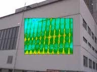 Termowizyjny obraz ściany budynku, ukazujący rozkład temperatur w kolorach od zielonego do żółtego, nałożony na fasadę budynku z widocznymi oknami.