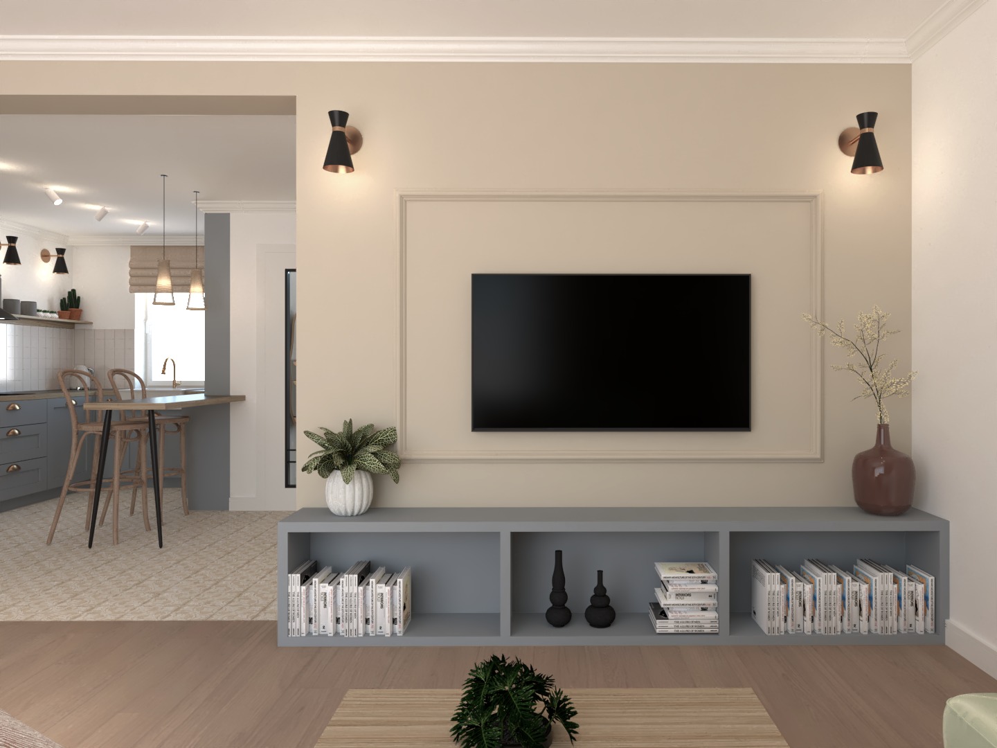 Salon z telewizorem zawieszonym na ścianie z dekoracyjną ramą, szarą szafką RTV z książkami i ozdobami, widok na kuchnię z barkiem i krzesłami barowymi, oświetlenie punktowe.