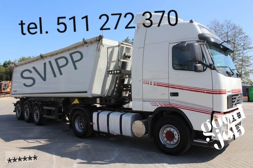 Biała ciężarówka Volvo z naczepą typu wywrotka, z napisem SVIPP na burcie, numer telefonu nad kabiną, zaparkowana na placu.