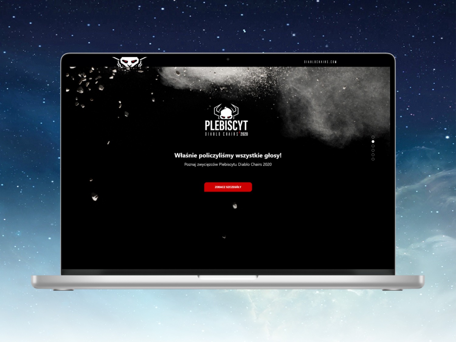 Laptop wyświetlający stronę internetową DiabloChairs.com z informacją o wynikach plebiscytu, na tle rozgwieżdżonego nieba.