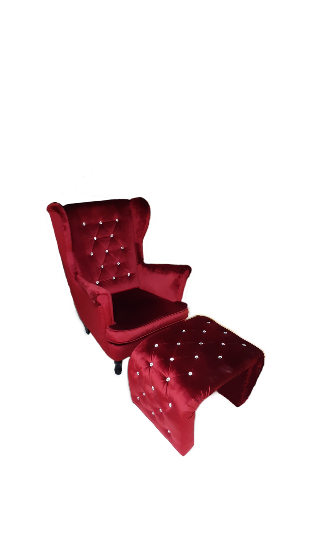 Czerwony fotel typu uszak z podnóżkiem, tapicerowany welurem i zdobiony kryształkami, na białym tle.