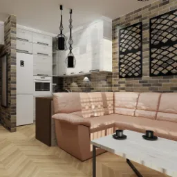 Wnętrze salonu z aneksem kuchennym, beżowa sofa narożna, stolik kawowy z dwoma filiżankami, ściana z cegły, dekoracyjne panele ścienne, podłoga z parkietu w jodełkę, wiszące lampy o ażurowych...