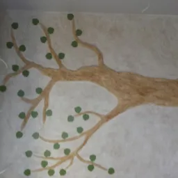 Ręcznie malowane drzewo z zielonymi liśćmi na ścianie z efektem betonu w łazience, widoczne fragmenty kabiny prysznicowej i niezakończone prace wykończeniowe.