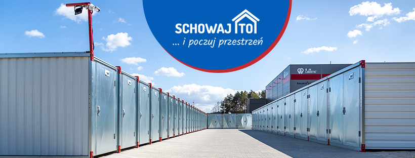 Rząd zewnętrznych, metalowych boksów do samoobsługowego przechowywania, z logo firmy na górze kadru i monitoringiem na pierwszym boksie.