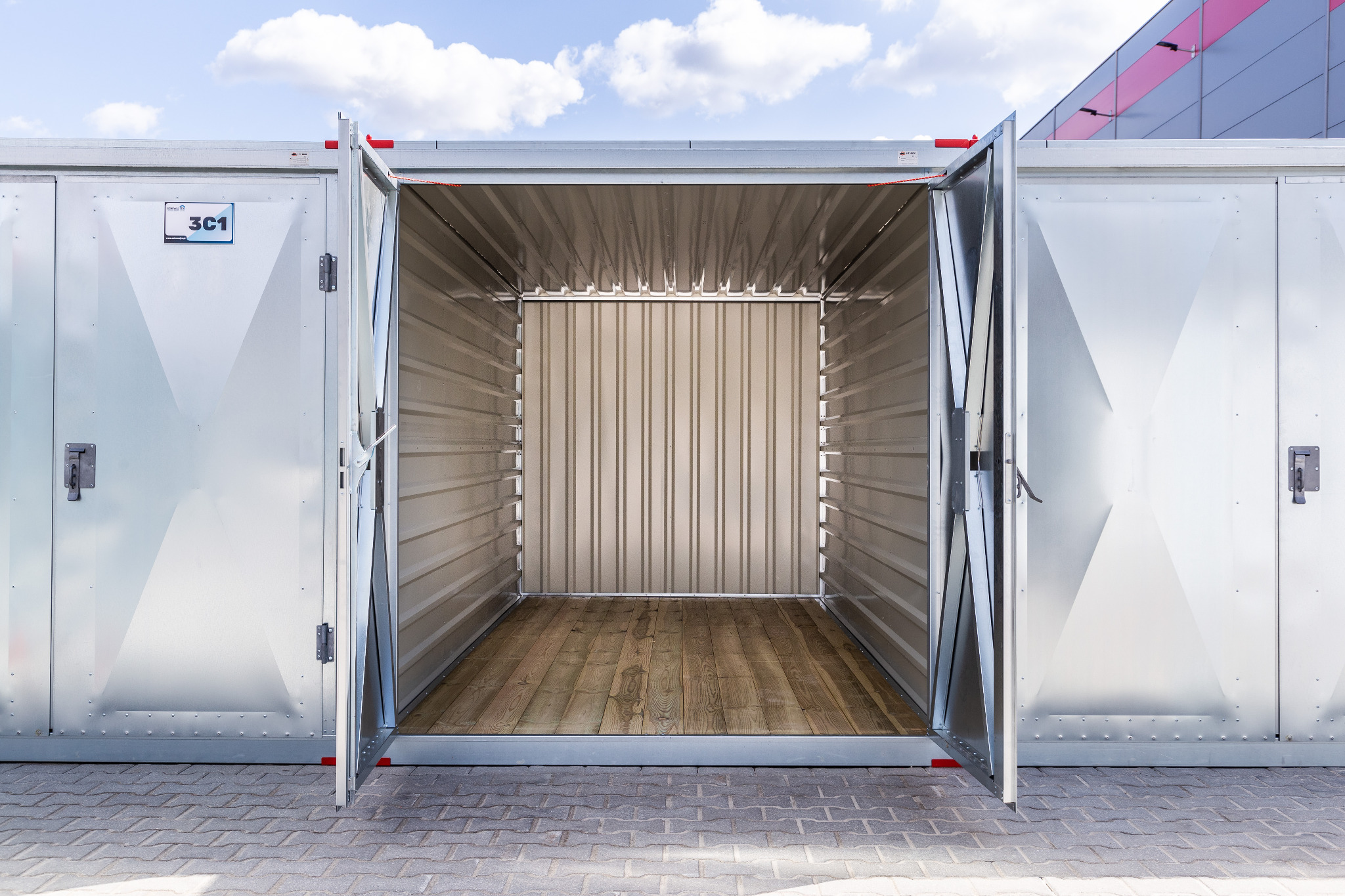 Otwarty, metalowy kontener magazynowy z drewnianą podłogą w Zielonej Górze, widok z zewnątrz na puste wnętrze.