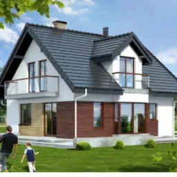 Dwukondygnacyjny dom z szarą dachówką, balkonem z przezroczystą balustradą i elementami drewnianej elewacji, widoczny z perspektywy ogrodu z kwitnącymi magnoliami i spacerującymi osobami.