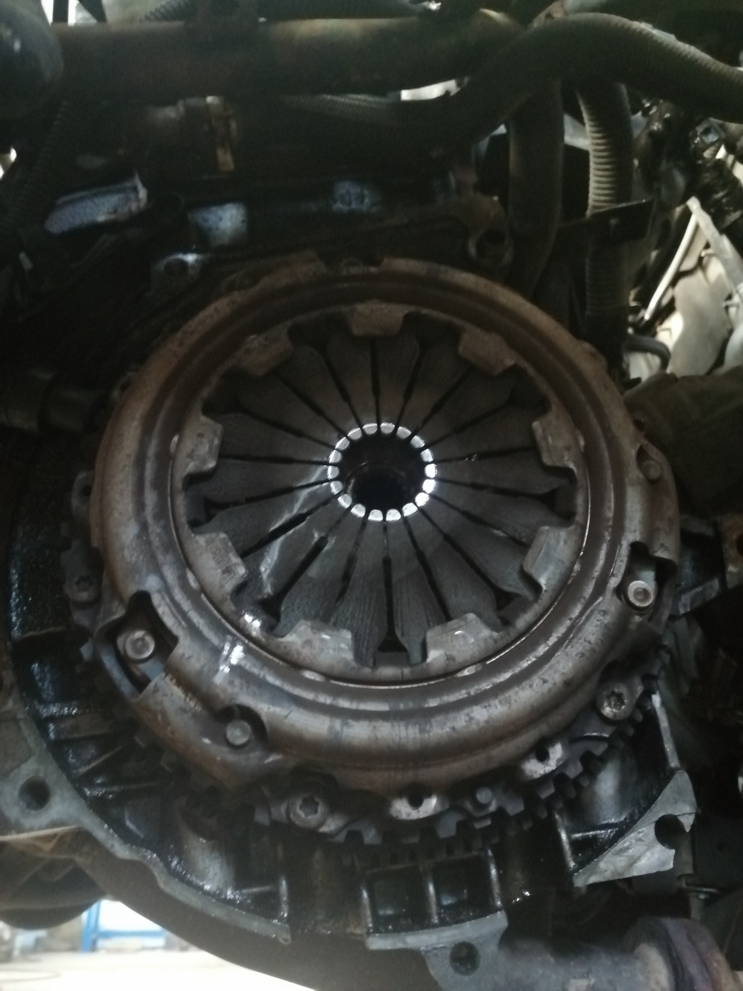 Olejny silnik samochodowy z widocznym sprzęgłem i tarczą sprzęgłową, ukazujący zużycie elementów.