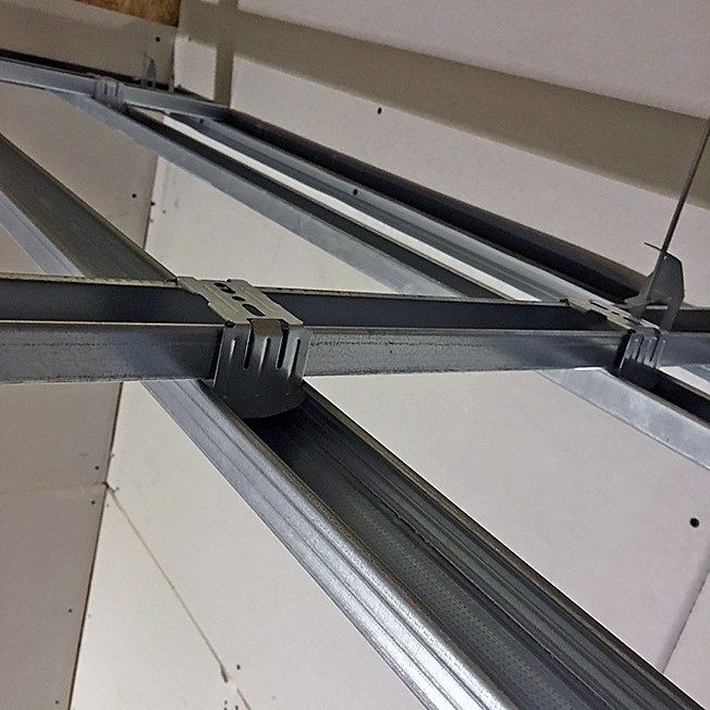 Metalowa konstrukcja nośna pod panele, widok od dołu, z perforowanymi profilami i mocowaniami.