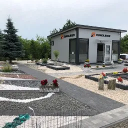 Ekspozycja różnorodnych nawierzchni z kamienia ozdobnego i żwiru przed biurem firmy Eurolider, prezentująca aranżacje ogrodowe z wykorzystaniem kamieni w różnych kolorach i fakturach.