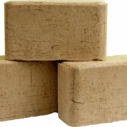 Trzy kostki sprasowanych trocin, ułożone jedna na drugiej, widoczne delikatne pęknięcia na powierzchni, jasne tło.