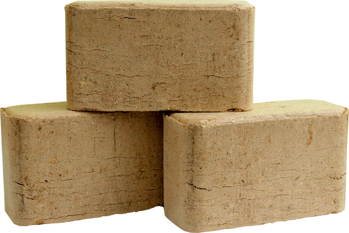 Trzy kostki sprasowanych trocin, ułożone jedna na drugiej, widoczne delikatne pęknięcia na powierzchni, jasne tło.