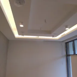 Pokój w trakcie wykańczania z podwieszanym sufitem z oświetleniem LED i punktowymi lampami, widoczne kable wystające z sufitu, podłoga zabezpieczona folią malarską.