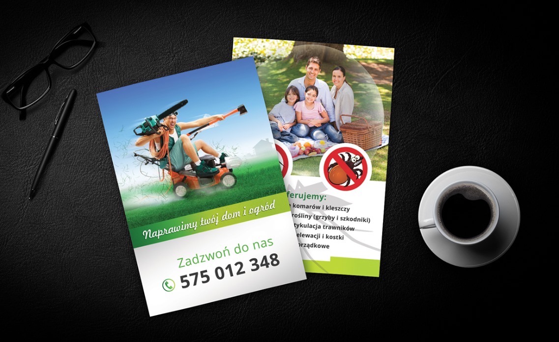 Ułożone na czarnym biurku ulotki reklamowe firmy Clean Garden z grafiką mężczyzny na kosiarce z piłą łańcuchową i rodziny na pikniku, obok filiżanka kawy i okulary.