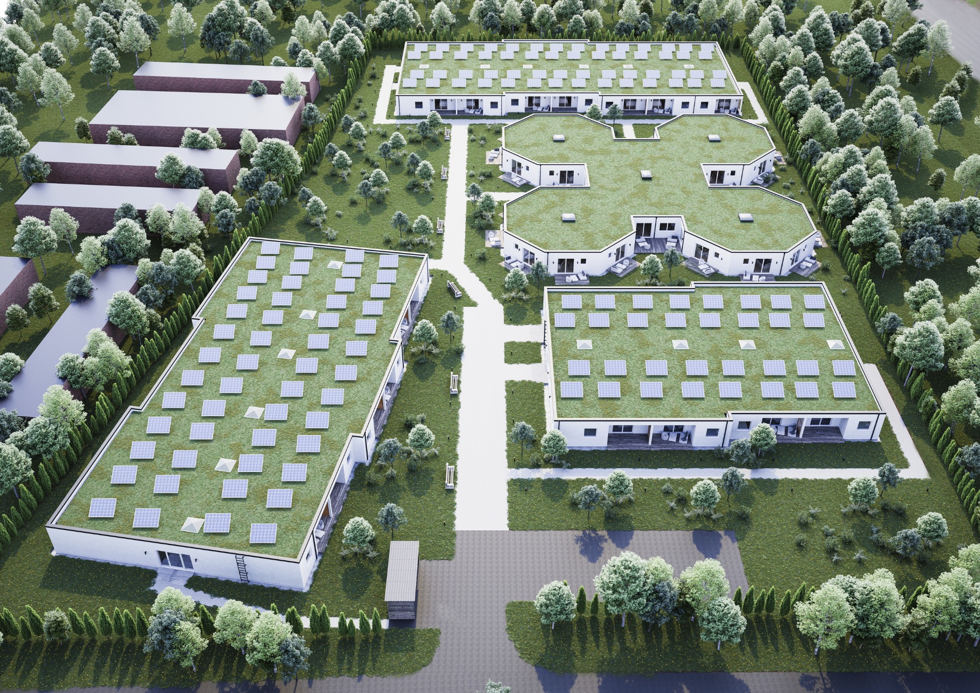 Widok z lotu ptaka na kompleks budynków z zielonymi dachami pokrytymi panelami słonecznymi, otoczonych zielenią i drzewami.